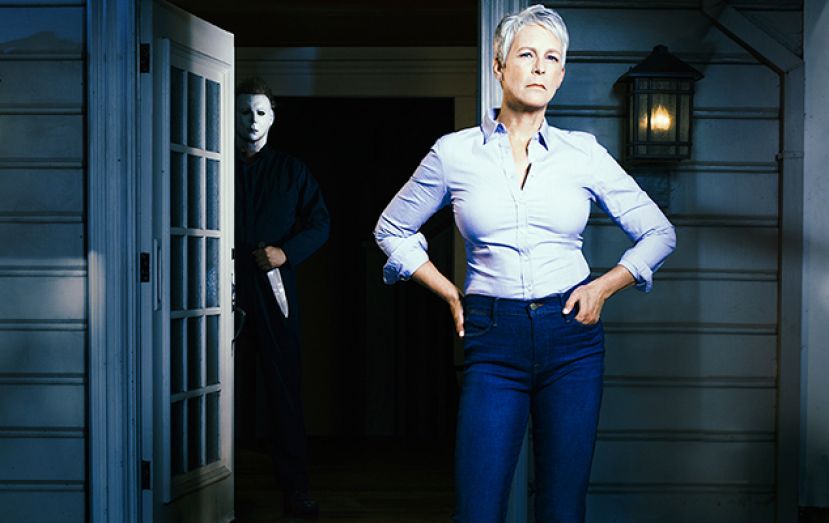 Laurie Strode (Jamie Lee Curtis) standing on the front porch of a house, while Mike Myers (Nick Castle) is behind her in the doorway holding a knife