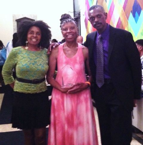 Award-winning author Selma Jackson holding her Phillis Wheatley Book Award for Young Readers surrounded by What&#039;s The 411 Book Editor Luvon Roberson (left) and Ansel Pitcairn, Illustrator of Granny&#039;s Helper.